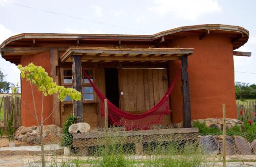 a small house with a red net in front of it at Bio Chalé Carrancas in Carrancas