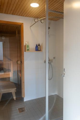 a shower with a glass door in a bathroom at Architectural townhouse with sauna and patio in Helsinki