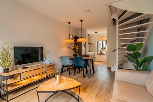 a living room with a tv and a dining room at Boutique Resort Schaardijk vakantiewoning in Scharendijke