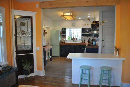 a kitchen with a white counter and two bar stools at Private Hot Tub - 3 bedroom Village Home in Fleischmanns