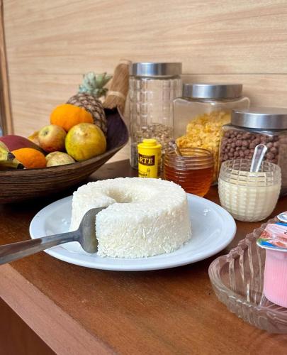 a piece of cake on a plate with a spatula at Pousada Pangea Tropical in Arraial d'Ajuda