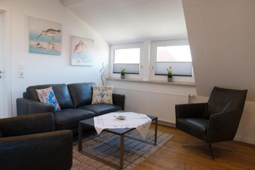 a living room with a couch and two chairs and a table at Deichnähe C in Norddeich