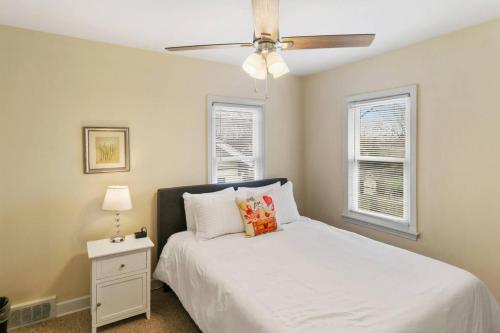 a bedroom with a white bed and a ceiling fan at Downtown Libertyville Duplex Near Naval Base in Libertyville