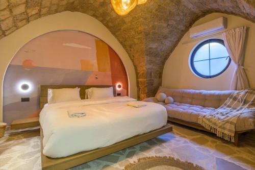 a bedroom with a large bed and a couch at Beit Chams 3 Suites in Batroun in Batroûn