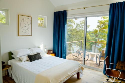 a bedroom with a bed and a sliding glass door at Wildcat Modern - 2br Firepit, Deck Dog Friendly in Young Harris