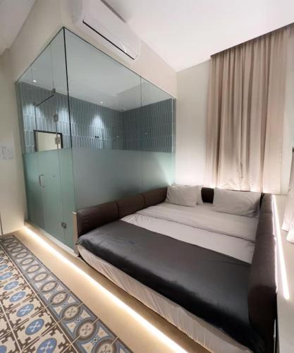 1 dormitorio con 1 cama grande y pared de cristal en Bhub Room 205 in Gemmayze, en Beirut