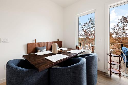 a dining room with a wooden table and blue chairs at Wildcat Modern - 2br Firepit, Deck Dog Friendly in Young Harris