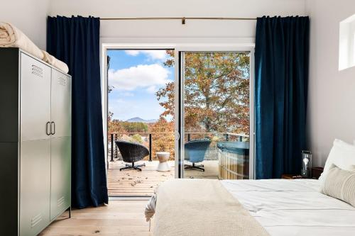 a bedroom with a bed and a sliding glass door at Wildcat Modern - 2br Firepit, Deck Dog Friendly in Young Harris