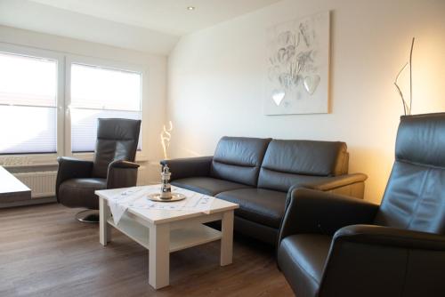 a living room with a couch and chairs and a table at Santa Maria in Norddeich
