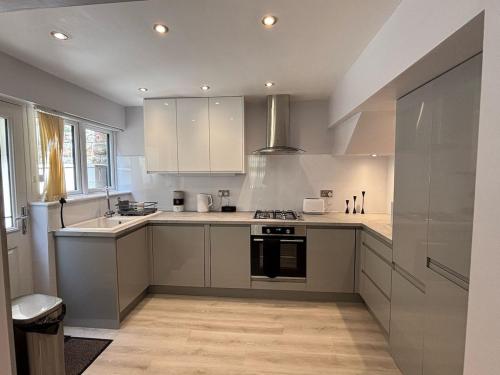 a kitchen with white cabinets and a stove top oven at Cosy home Nottingham The Park City centre free parking in Nottingham