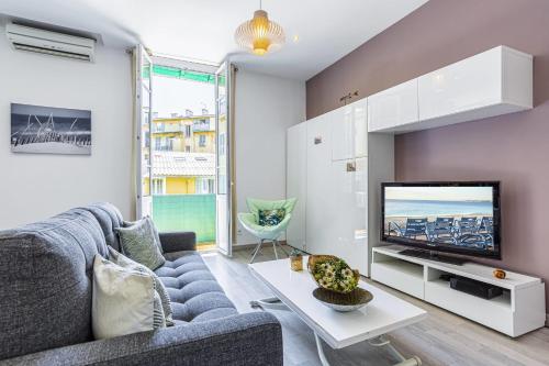 un salon avec un canapé et une télévision dans l'établissement GUISOL - Typical Nice 3 Bedroom AC near Port, à Nice