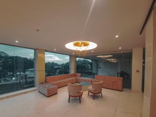 a living room with a couch and chairs and windows at Lavendish Hills Kandy in Kandy