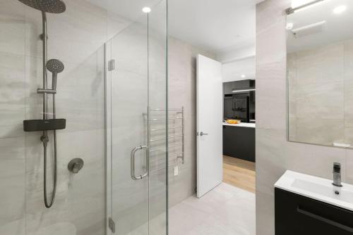 a bathroom with a glass shower and a sink at Mountainview Escape | Stylish, BBQ, and Parking in Wanaka