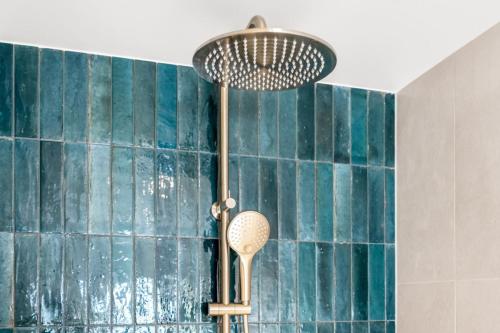 a shower in a bathroom with blue tiles at Beachfront Studio with Breathtaking Views in Kingston Beach