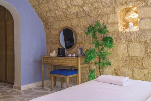 a bedroom with a bed and a table and a mirror at Beit Chams Sunset Suite in Batroun in Batroûn