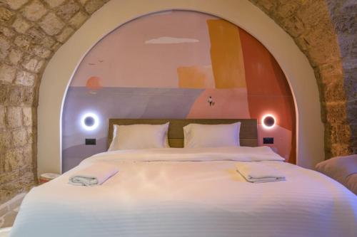 a bedroom with a large bed with an arch above it at Beit Chams Sunset Suite in Batroun in Batroûn