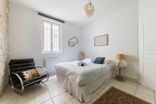 une chambre blanche avec un lit et une chaise dans l'établissement Appartement familial proche des commerces - 8P - FLAT-GUEST, à Paris