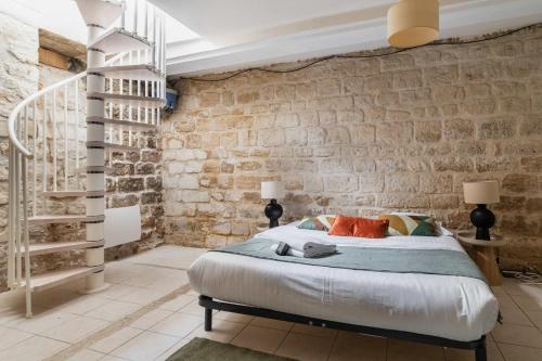 une chambre avec un lit et un mur de briques dans l'établissement Appartement familial proche des commerces - 8P - FLAT-GUEST, à Paris