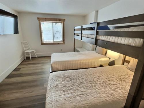 a room with two bunk beds and a window at Large Modern Driggs Home with Game Room and Jacuzzi! in Driggs