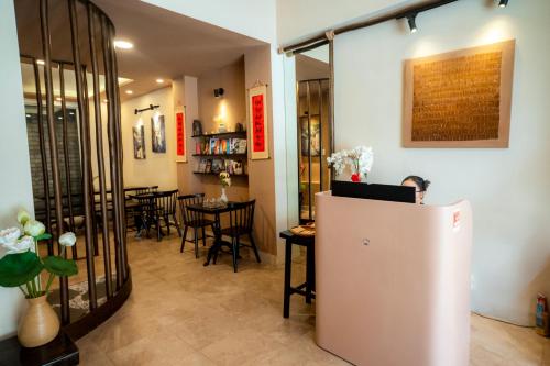 a room with a refrigerator and a table with chairs at HemTouch House in Ho Chi Minh City