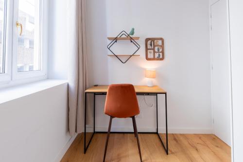un bureau avec une chaise et une lampe. dans l'établissement Le Palais Boursier - Cordeliers, à Lyon