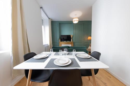 une salle à manger avec une table et des chaises blanches dans l'établissement Le Palais Boursier - Cordeliers, à Lyon