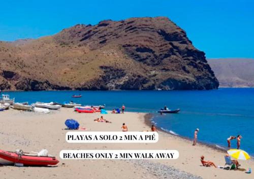 a group of people on a beach with a mountain in the background at Apartalux Sublime Plus in Las Negras