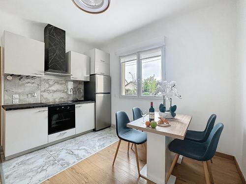 - une cuisine avec une table et des chaises bleues dans la chambre dans l'établissement Le Nid - Paris - Le Blanc Mesnil, au Blanc-Mesnil