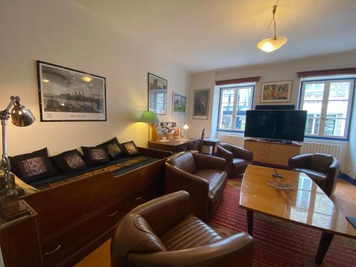 un salon avec un canapé, des chaises et une table dans l'établissement Jardin paisible en centre-ville, à Auray