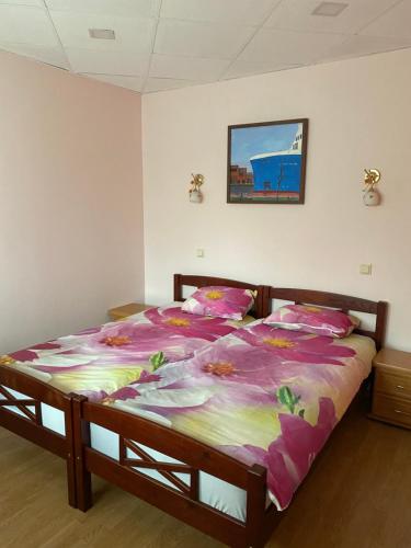 a bedroom with a large bed with a colorful comforter at Apartment Hotel Rubini in Ventspils