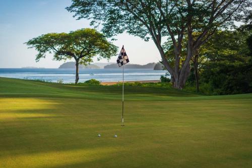 a golf course with a flag on the green at Beautifully Remodeled Condo w - Pool in Playa Conchal