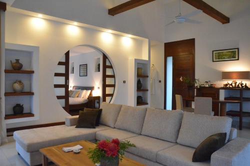 a living room with a couch and a mirror at Cominsia Lodge in Kep