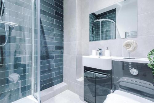 a bathroom with a sink and a shower at The Cosy Quarters - Popworks in Manchester