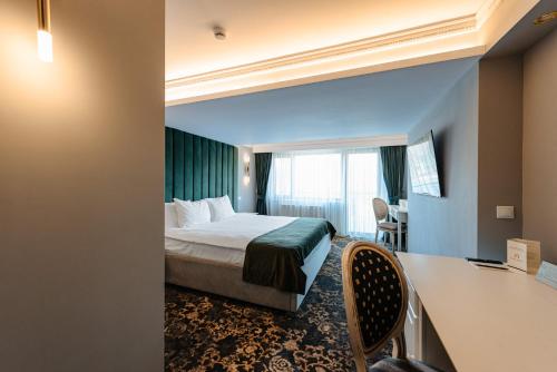 a hotel room with a bed and a desk at SunGarden Golf & Spa Resort in Cluj-Napoca
