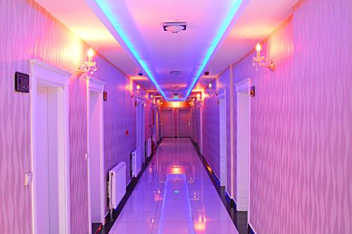 an empty hallway with purple and blue lights at maciter hotel in Erciş