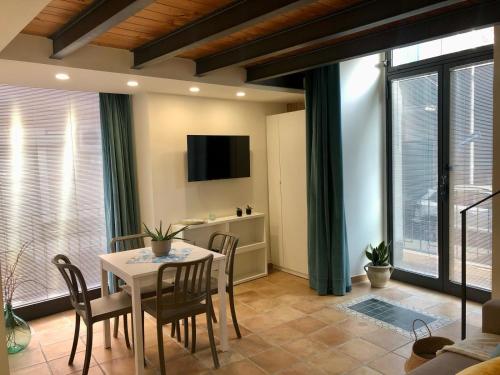 アーチ・カステッロにあるA Casa di Rossのテーブルと椅子とテレビのあるダイニングルーム