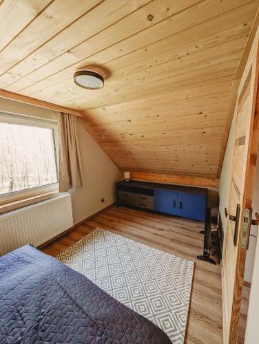 a bedroom in a tiny house with a bed and a window at Beskidzka Kraina in Porąbka