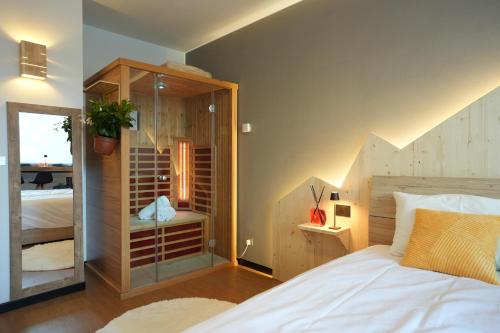 a bedroom with a white bed and a glass door at Sauna Relax in Piancavallo mountain in Piancavallo