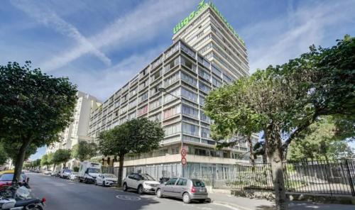 un grand bâtiment avec un panneau en haut dans l'établissement Bright studio, à Vanves