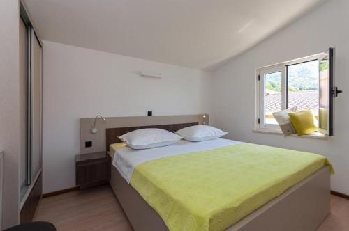 Un dormitorio con una cama grande con una manta amarilla. en Villa Roko, en Omiš