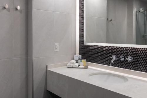 a bathroom with a sink and a mirror at Hotel Bonaventure Montreal in Montréal