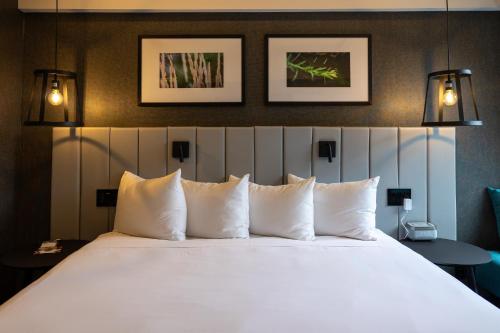 a bedroom with a large bed with white pillows at Hotel Bonaventure Montreal in Montréal
