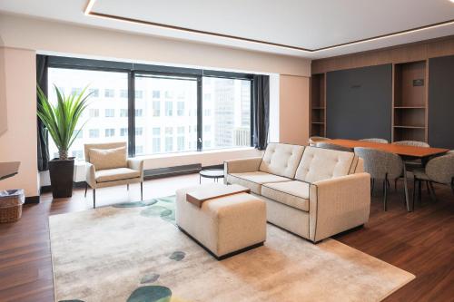 a living room with a couch and chairs and a table at Hotel Bonaventure Montreal in Montréal