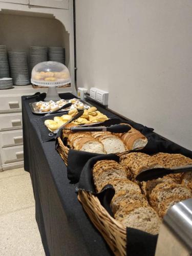 a table topped with lots of different types of bread at Hotel Lyon by MH in Buenos Aires