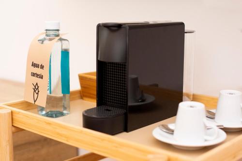a black microwave sitting on a shelf next to a bottle at O Camiño Fala Hotel in Mazaricos