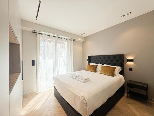 une chambre avec un grand lit et une grande fenêtre dans l'établissement DUBOY D ANGERS MARRIOTT Cannes, à Cannes
