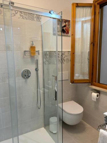 a bathroom with a toilet and a glass shower at Dolce Dormire in Castiglione del Lago