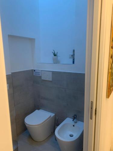 a bathroom with a white toilet and a sink at Luciano Home in Gonnesa