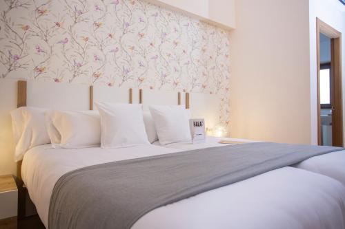 a bedroom with a large bed with a floral wallpaper at O Camiño Fala Hotel in Mazaricos