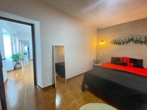 a bedroom with a large bed and a mirror at House In The Valley in Algarvia
